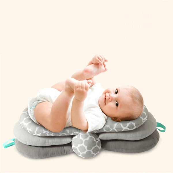 Un bébé allongé sur un coussin d'allaitement sur fond beige