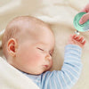 La tête d'un bébé allongé qui dort, juste sa main vers le haut et une main de femme avec un coupe ongle électrique pour lui couper les ongles.